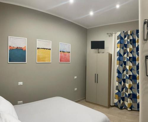 a bedroom with a bed and paintings on the wall at Miambra in Grumo Nevano