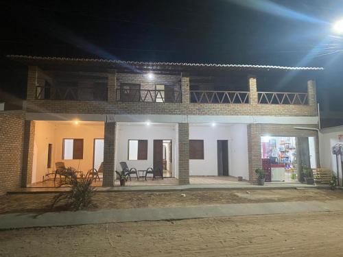 a brick house with a balcony at night at Pousada manu in Trairi