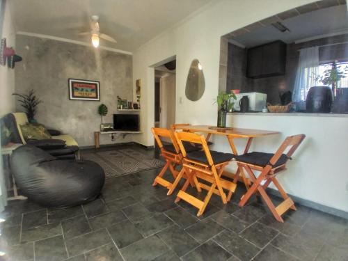 uma sala de estar com mesa e cadeiras em Apartamento em Guarujá Praia do Tombo, 300mts do mar - TOMBO BEACH HOST no Guarujá