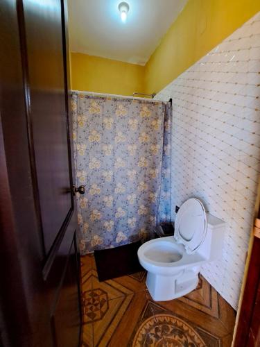 a bathroom with a toilet and a shower at La Mansión del Gran Jaguar in Retalhuleu