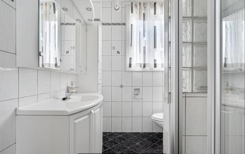 a white bathroom with a sink and a toilet at Historical villa in the city center in Tromsø