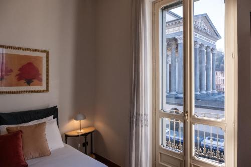 a bedroom with a bed and a large window at L'Angolo di Casa Verrua in Turin