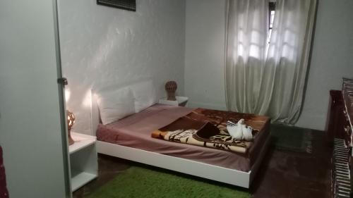 um quarto com uma cama com uma janela e um espelho em the river house em Aghbalou