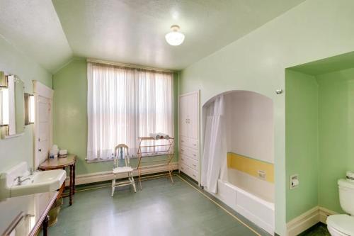 La salle de bains est pourvue de murs verts, d'un lavabo et de toilettes. dans l'établissement Lodi Hill House, à Lodi
