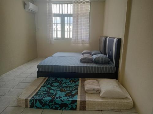 - une chambre avec 2 lits et un tapis au sol dans l'établissement BS Home in Miri City - 3R2B House, à Miri