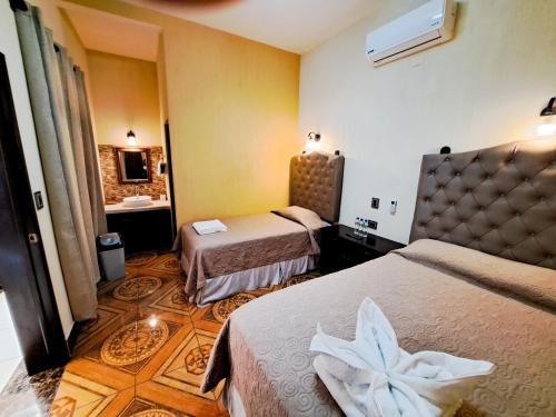a hotel room with two beds and a sink at La Mansión del Gran Jaguar in Retalhuleu