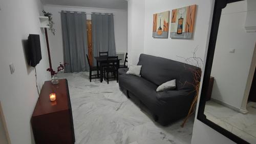 sala de estar con sofá negro y mesa en Vista Triunfo, en Granada