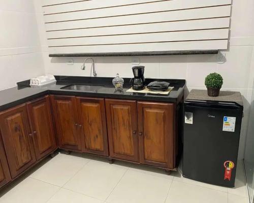 a kitchen with a sink and a refrigerator at Hospedagens Alex in Paraty