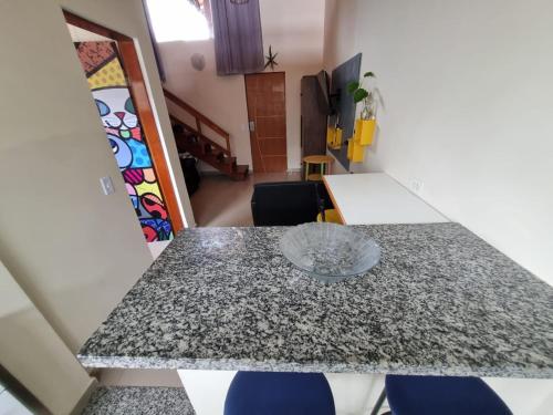 a dining room table with a granite counter top at Ohana's Flat Maresias in São Sebastião