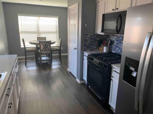 a kitchen with a stove and a table with chairs at 4Bed 2Bath Entire Home 