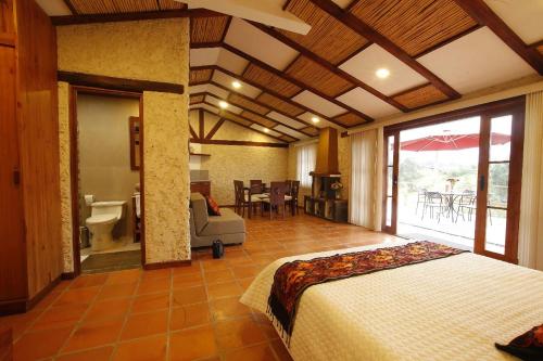 Un dormitorio con una cama y una habitación con baño. en Killary Lodge & Glamping, en Cachanlo de Sidcay