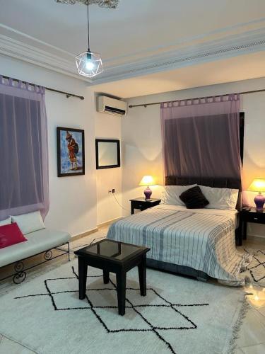 a bedroom with a bed and a table and two lamps at Paradise house in Marrakech