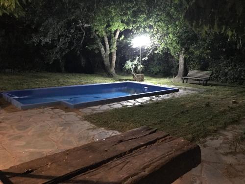 a blue swimming pool in a park at night at Casa La Florida in Mar del Plata