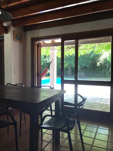 een houten tafel en stoelen in een kamer met een raam bij Casa La Florida in Mar del Plata