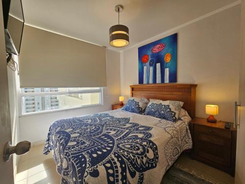 sypialnia z łóżkiem z niebiesko-białą kołdrą w obiekcie Oceana Suites Marina Del Sol w mieście La Serena