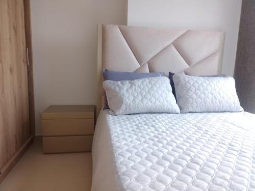 a bedroom with a white bed with a large headboard at Cozy Apartment in Pinares de San Martin. ¡PEREIRA! in Pereira