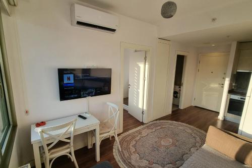uma sala de estar com uma mesa e uma televisão na parede em Inistanbul Apartments em Istambul