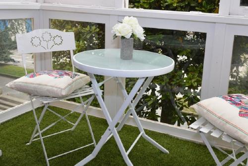 una mesa y dos sillas sentadas en un porche en Hostel Santander, en Santander