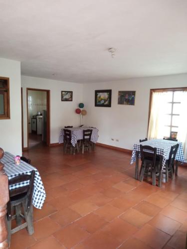 sala de estar con mesas y sillas y suelo en Hostal central en Villa de Leyva