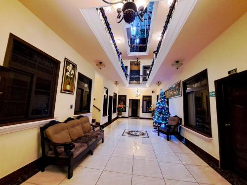 un salon avec un arbre de Noël au milieu dans l'établissement La Mansión del Gran Jaguar, à Retalhuleu
