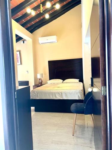 a bedroom with a bed and a blue chair at Kasa Morelos Hotel Boutique in Concordia