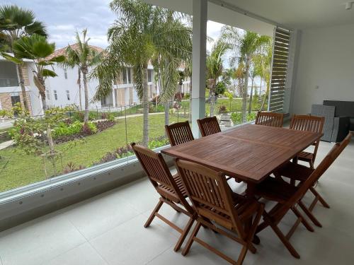 a dining room with a wooden table and chairs at Ananahi plage in Paea