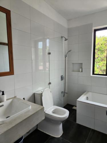 a bathroom with a toilet and a sink and a shower at Graystone at Oyster Bay in Dar es Salaam