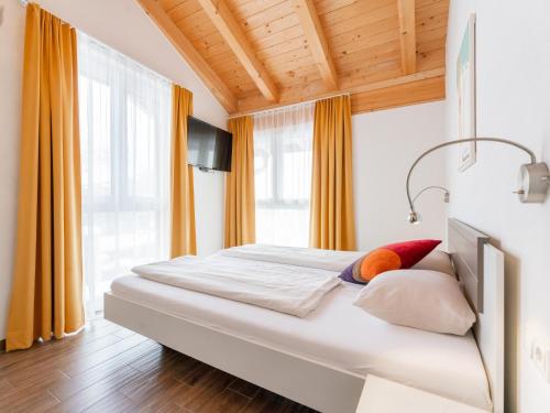 um quarto com uma grande cama branca com cortinas laranja em Emma Top 4 em Dienten am Hochkönig