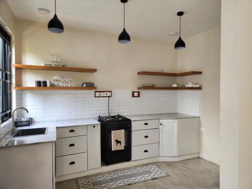 a kitchen with white cabinets and a black stove at Graystone at Oyster Bay in Dar es Salaam