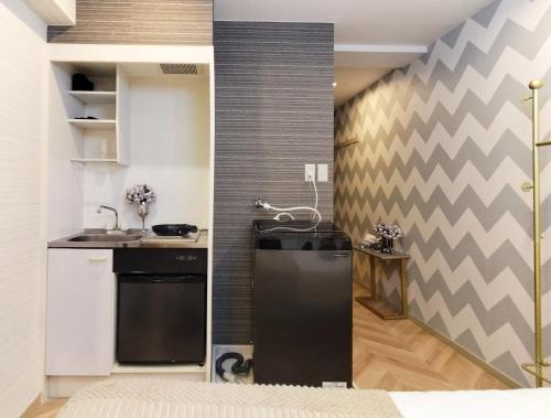 cocina con nevera negra en una habitación en G23新宿最中心 東新宿站5分-Shinjuku center 5 mins to Station, Max 3P 新宿 涉谷 表参道 池袋 上野 代代木 银座 原宿, en Tokio