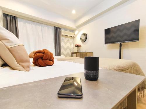 una habitación de hotel con una cama y un teléfono móvil en una mesa en G23新宿最中心 東新宿站5分-Shinjuku center 5 mins to Station, Max 3P 新宿 涉谷 表参道 池袋 上野 代代木 银座 原宿, en Tokio
