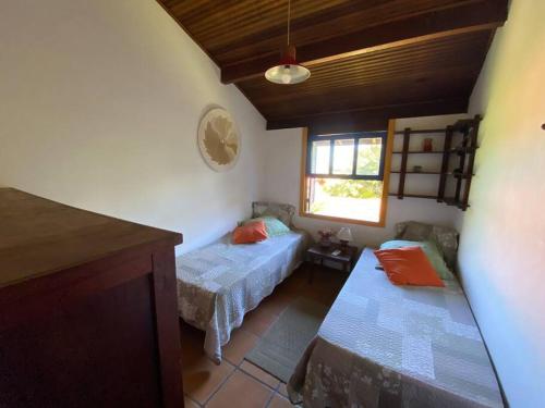 a small room with two beds and a window at Casa na Colina de Geribá, Búzios in Búzios