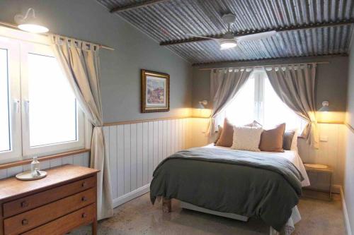 een slaapkamer met een bed en een raam bij The Pottery Shed in Boambee