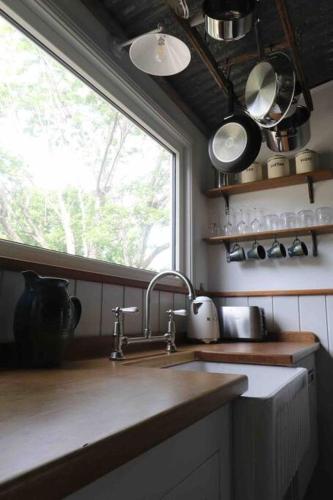 a kitchen with a sink and a window at The Pottery Shed in Boambee