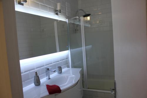 a white bathroom with a sink and a shower at Appart T3 kodjo in Pessac