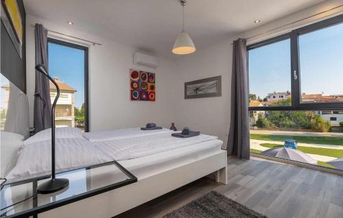 ein Schlafzimmer mit einem großen Bett und einem großen Fenster in der Unterkunft Casa Maestral in Funtana