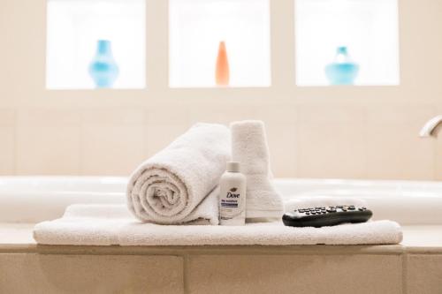 baño con toallas y mando a distancia en la bañera en Grand Hotel, en Spring City
