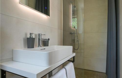 uma casa de banho com um lavatório branco e um chuveiro em Villa Sunset em Porec