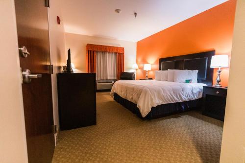a hotel room with a bed with an orange wall at Grand Hotel in Spring City