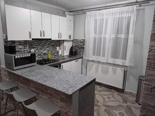 a kitchen with white cabinets and a counter top at Pleasure Palace in Sovata