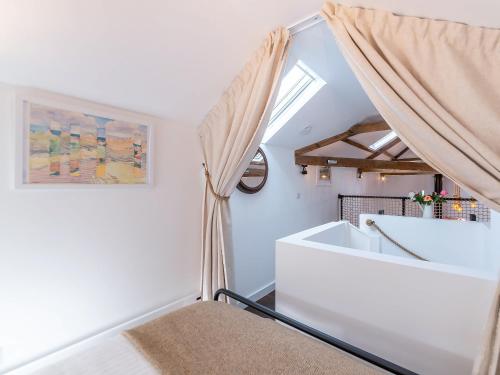 um quarto com uma janela e uma banheira em The Coach House At Orchard Place em Hexham