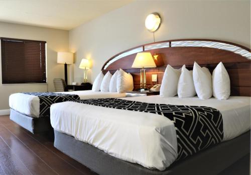 2 posti letto in camera d'albergo con grande testiera di Hotel Monte Carlo a Kissimmee