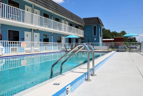 a swimming pool with a slide in front of a hotel at Hotel Monte Carlo in Kissimmee