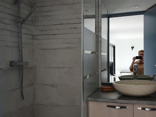 uma pessoa a tirar uma foto de uma casa de banho com um espelho em Architectural villa with swimming pool em Lorgues