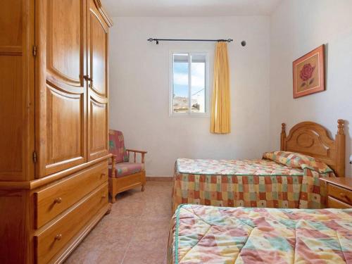 a bedroom with two beds and a dresser and a window at Beautiful apartment El Cardón with garden in Buenavista del Norte