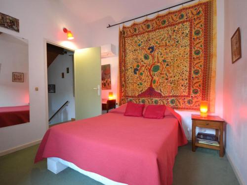 a bedroom with a pink bed with a large rug on the wall at Villa with swimming pool within the Luberon in Oppède