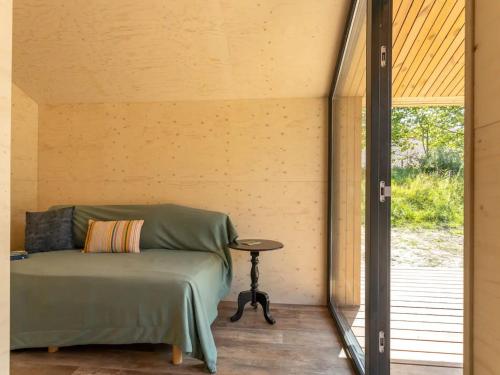 een kamer met een bed, een tafel en een raam bij Nature house on a beautiful and green domain in Kortgene