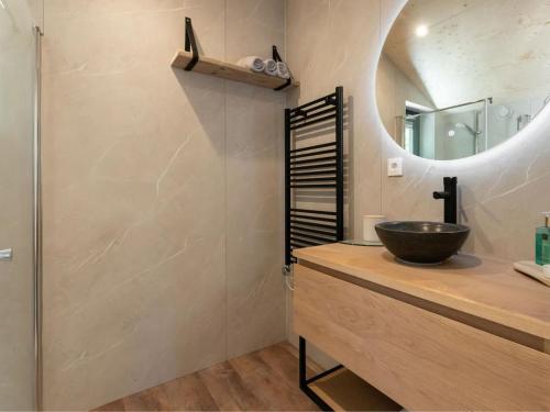 een badkamer met een wastafel en een spiegel bij Nature house on a beautiful and green domain in Kortgene