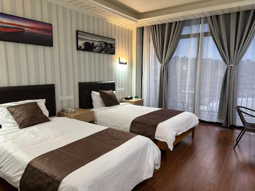 ホニアラにあるOutback Holiday Resortのベッド2台と窓が備わるホテルルームです。