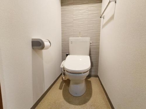 un bagno con un water bianco in una cabina di B25新宿最中心 新宿站10分-Shinjuku center 10 mins to Station, Max 4 直达新宿 涉谷 表参道 池袋 上野 代代木 银座 原宿 a Tokyo